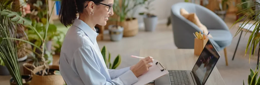 Image of a woman attending a virtual IOP from her laptop at home - Can You Attend Outpatient Rehab Online Using Carelon - Shanti Recovery and Wellness