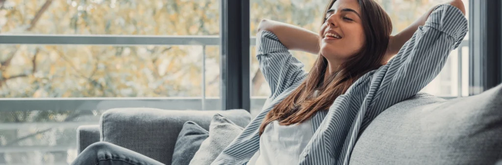 Image of a content woman lying back on a sofa - Setting Boundaries in Recovery - Shanti Recovery and Wellness