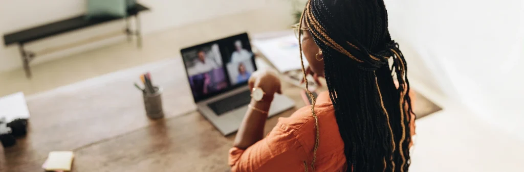 Image of a woman sitting in front of her laptop at a desk in a teleconference therapy session - Why Choose An IOP Online - Shanti Recovery and Wellness