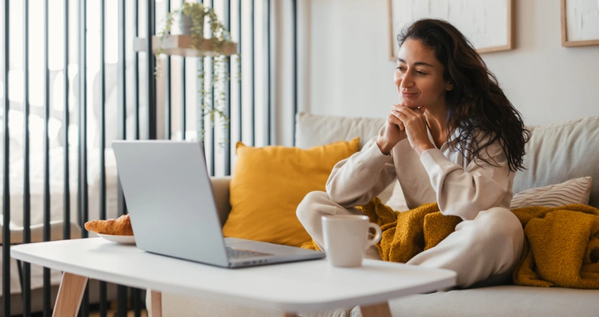 Image of a woman balancing work and virtual IOP treatment using laptop in home office setting