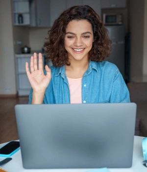 Image of a woman smiling at her laptop during a virtual check-in session for ongoing marijuana recovery support and monitoring