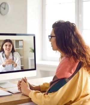 Image of a woman on a video call with her therapist receiving telehealth addiction counseling from home
