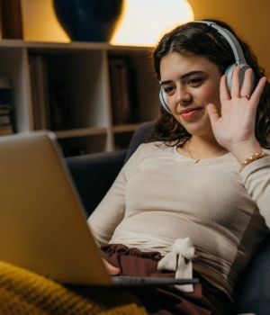 Image of a young adult wearing headphones in a private home space preparing for a secure virtual therapy session