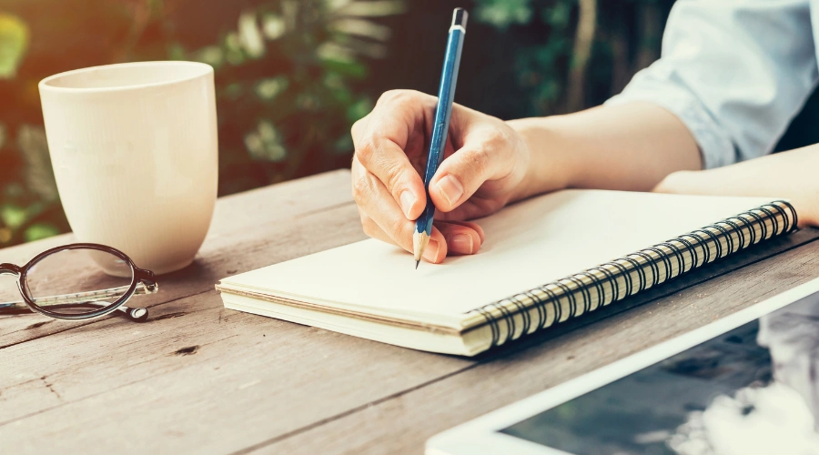 Image of a person writing in a notebook to plan relapse prevention strategies and manage cravings